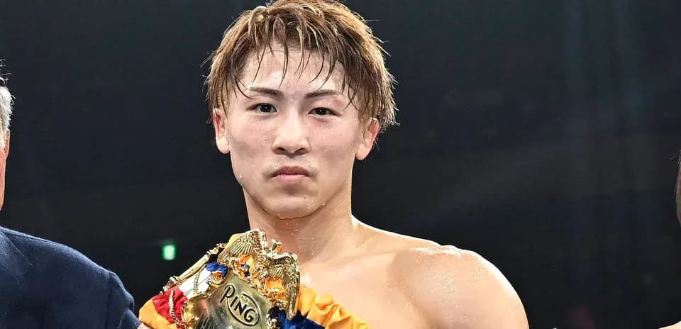 Boxer holding championship belt after winning match