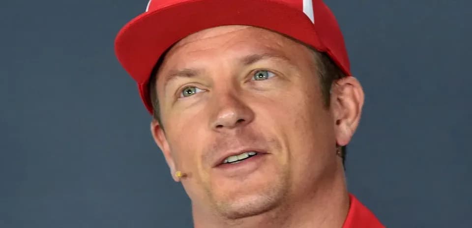 Driver speaking at press conference wearing red cap