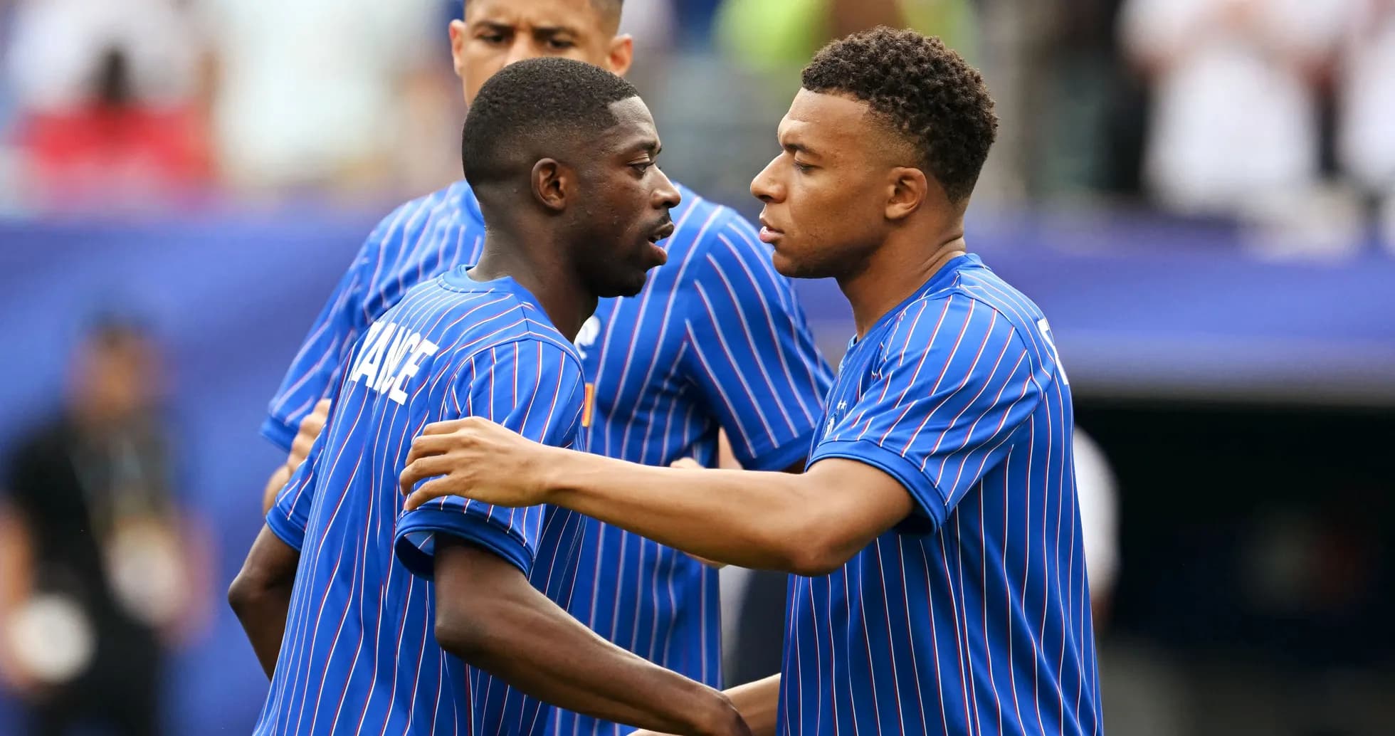 Two players in blue jerseys interacting before match