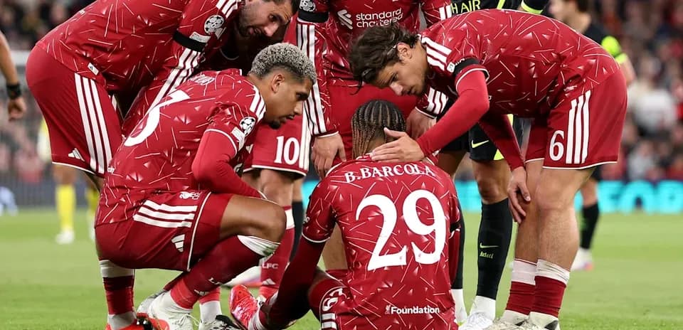 Liverpool players supporting injured teammate on pitch