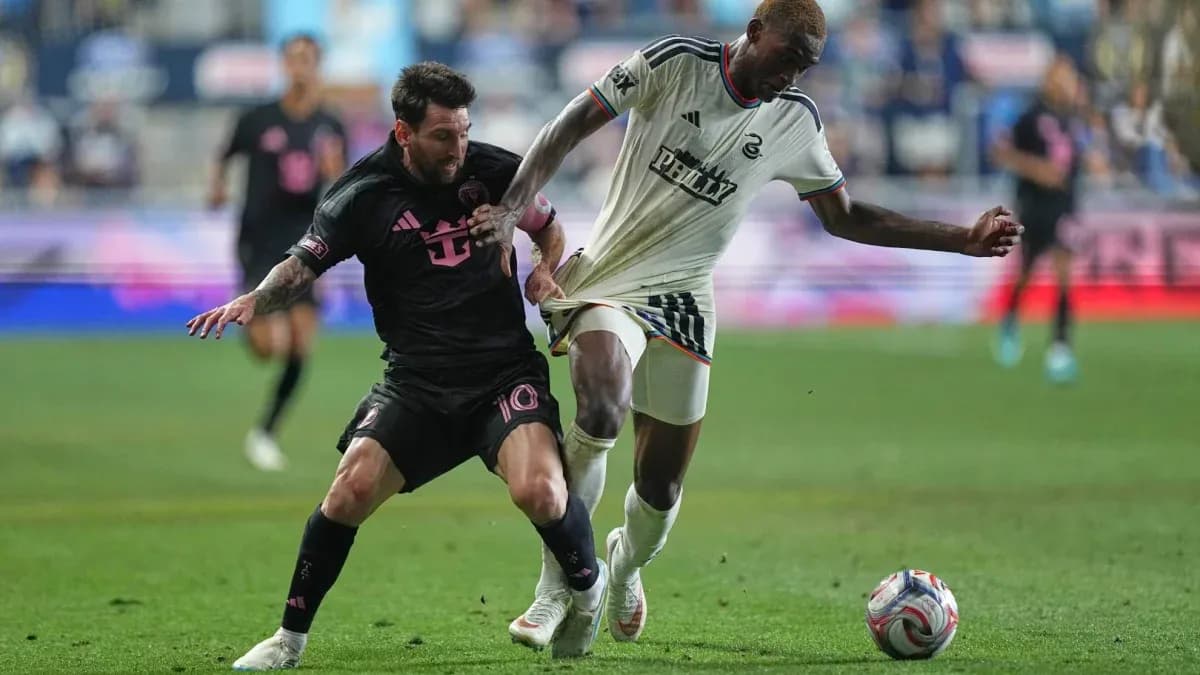 Lionel Messi and defender contesting for the ball
