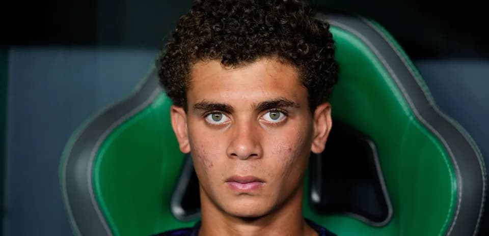 Young player sitting on bench with serious expression