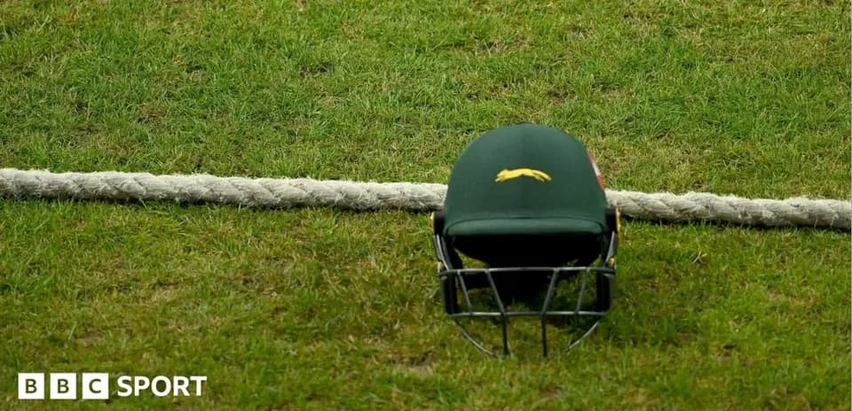 Cricket helmet resting on the grass near boundary