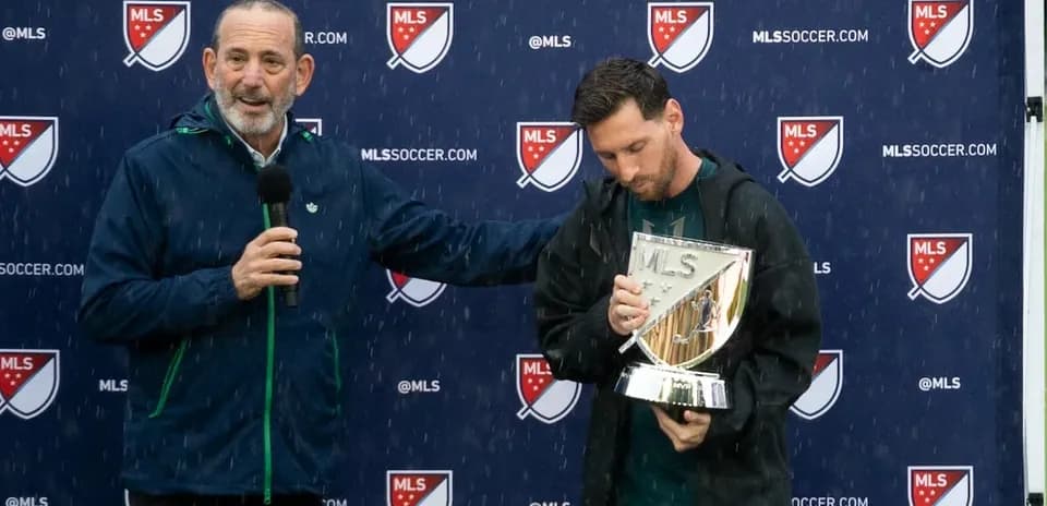 Player holding MLS trophy during press event