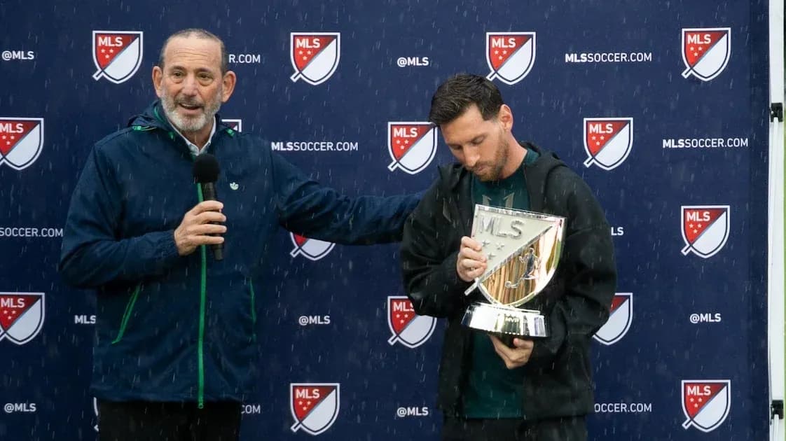Player holding MLS trophy during press event