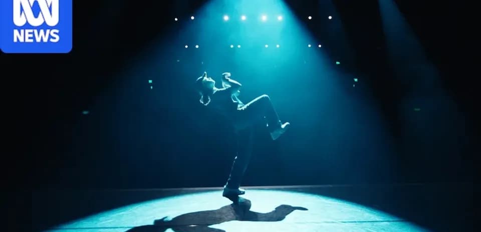 Dancer performing on stage under spotlight