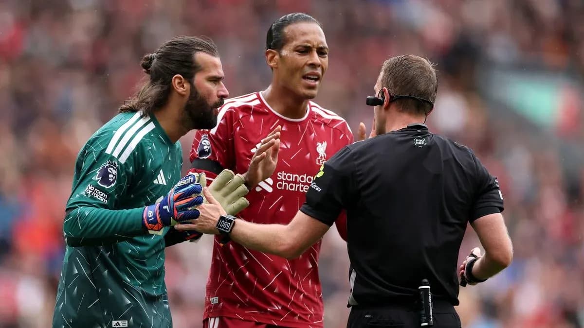 Goalkeeper and defender discussing with referee during match