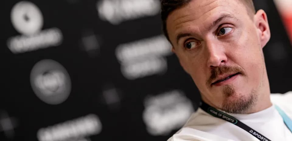Athlete at a press conference with media backdrop