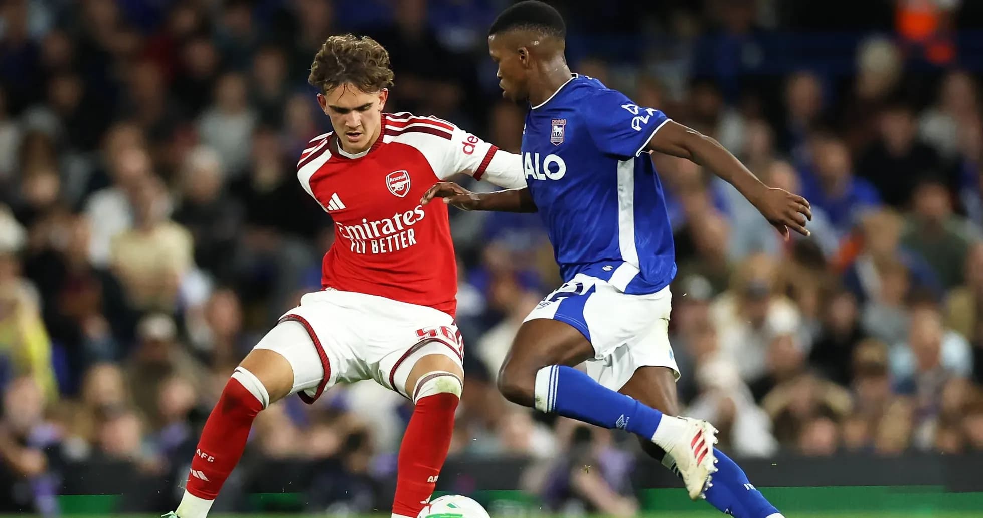 Player in red and player in blue contesting for the ball