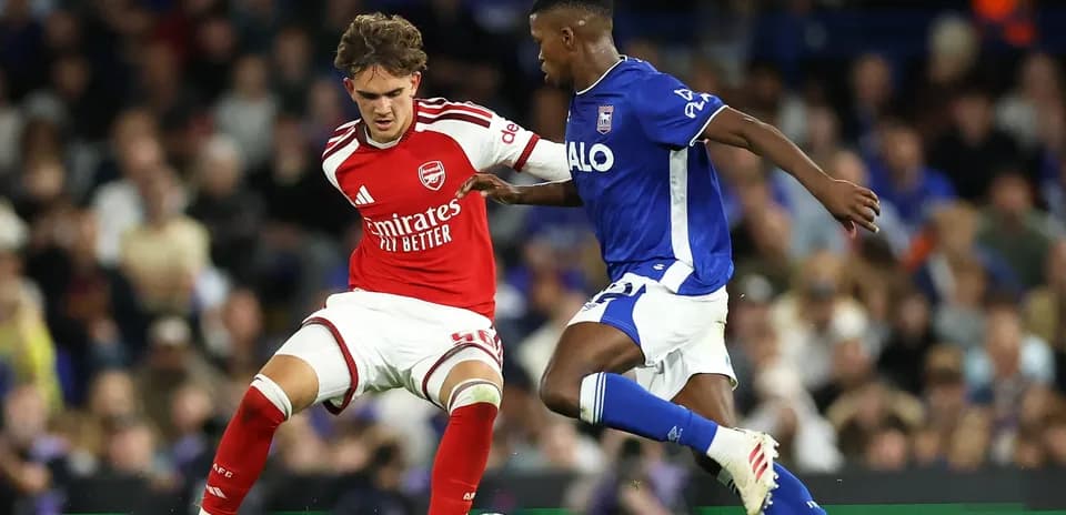 Player in red and player in blue contesting for the ball