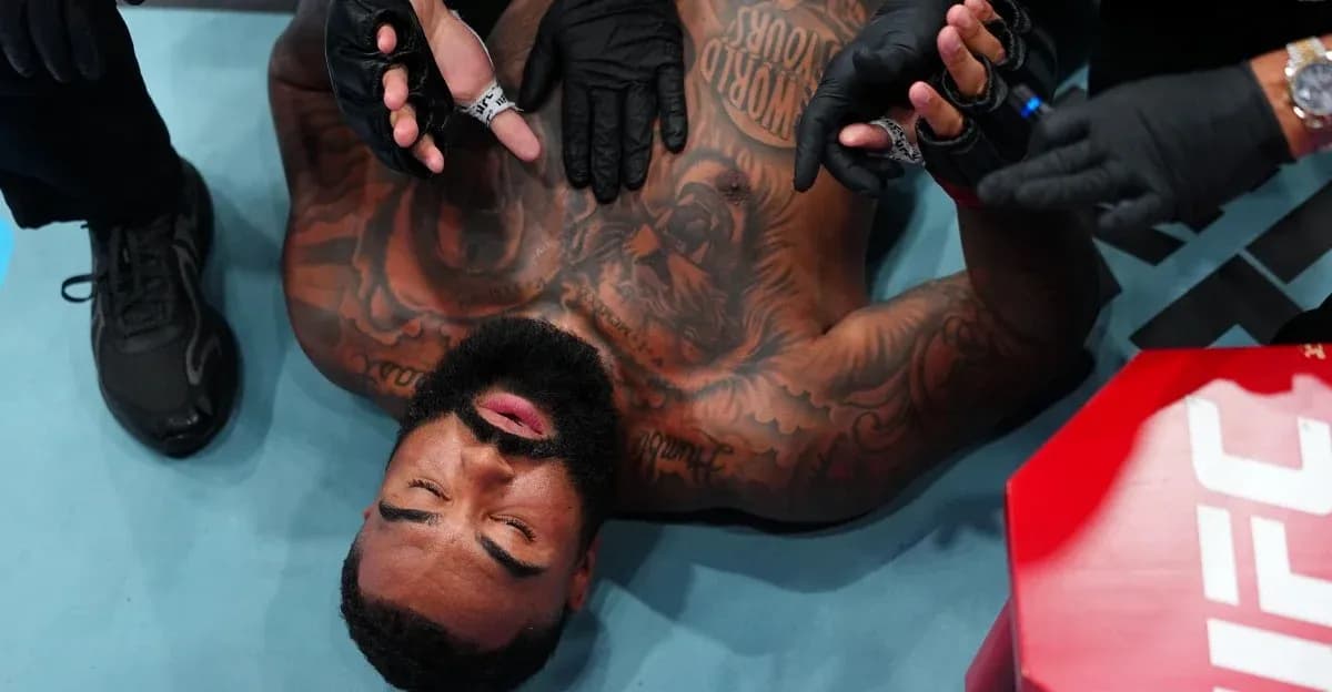 Fighter on the mat with medical personnel attending