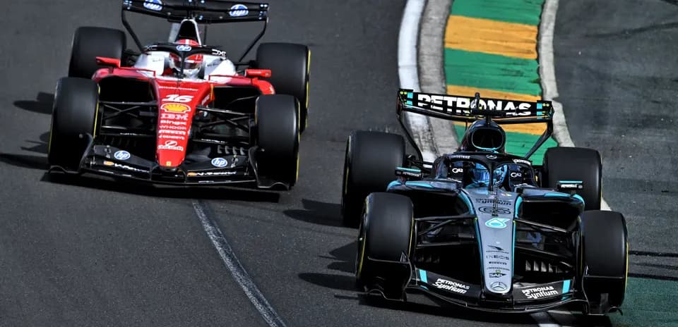 Two Formula 1 cars racing on track during competition