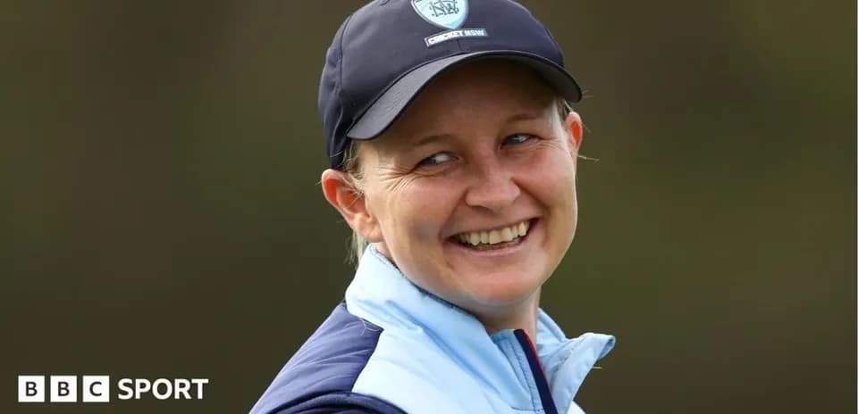 Smiling woman wearing a cap and jacket outdoors