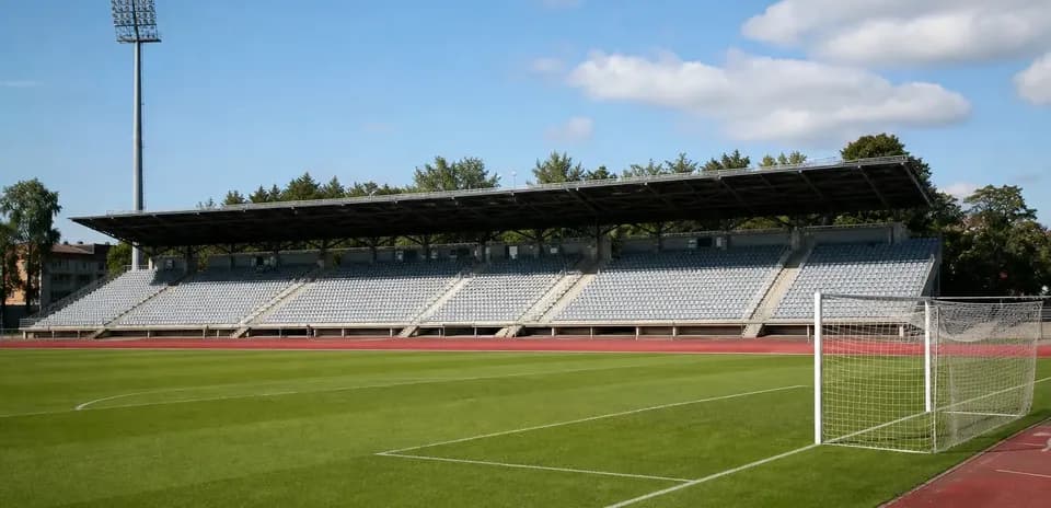 Empty football stadium with seating and goal post