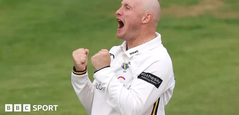 Cricketer celebrating with clenched fists on field