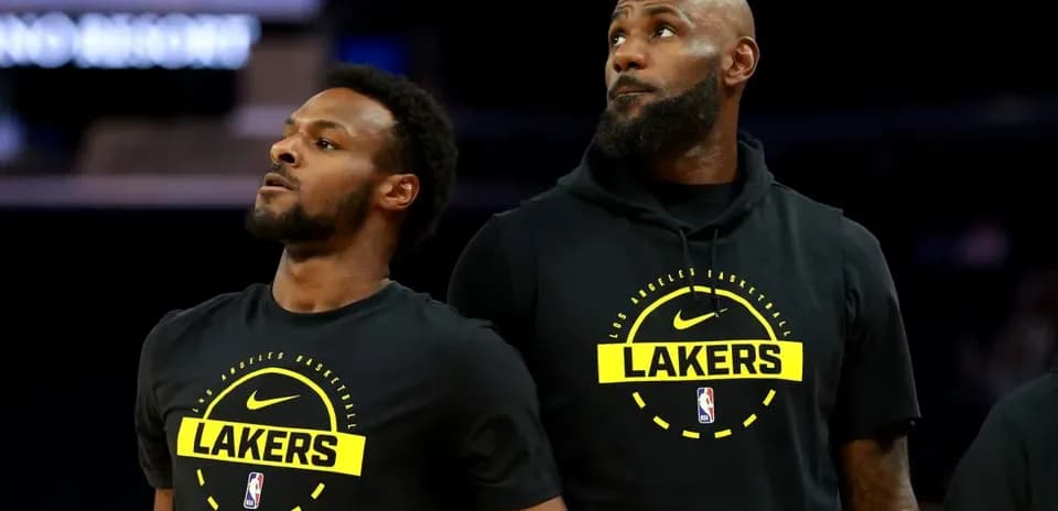 Two Lakers players in team hoodies during warm-up