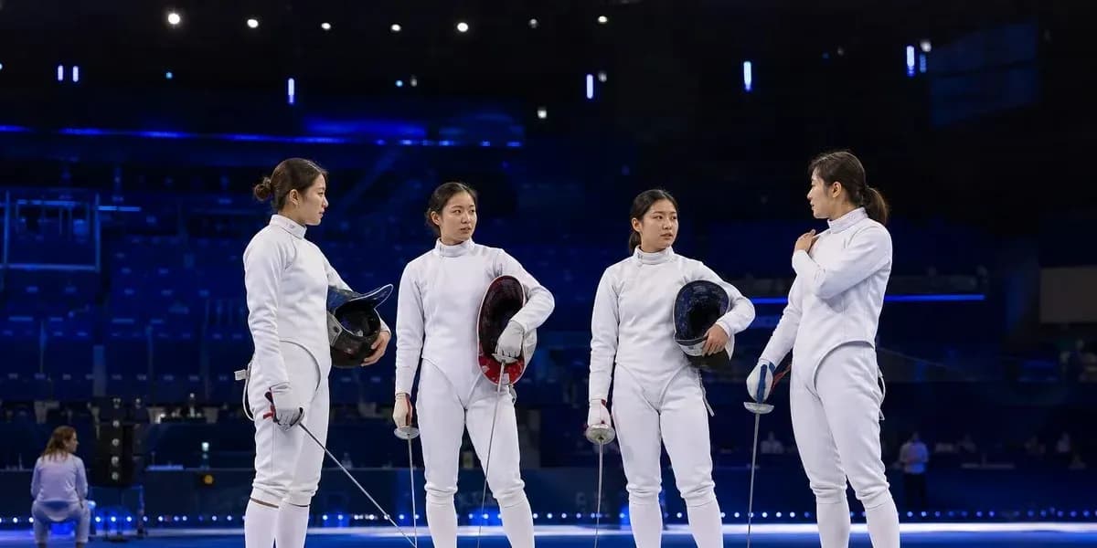 Four fencers discussing strategy on the piste