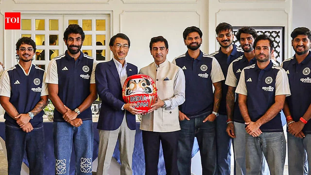 Cricket team posing with a ceremonial daruma doll
