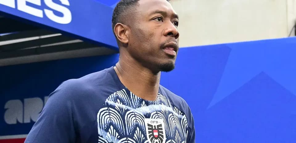 Player walking onto the pitch holding a soccer ball