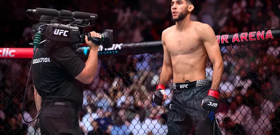 Fighter in octagon with camera crew filming