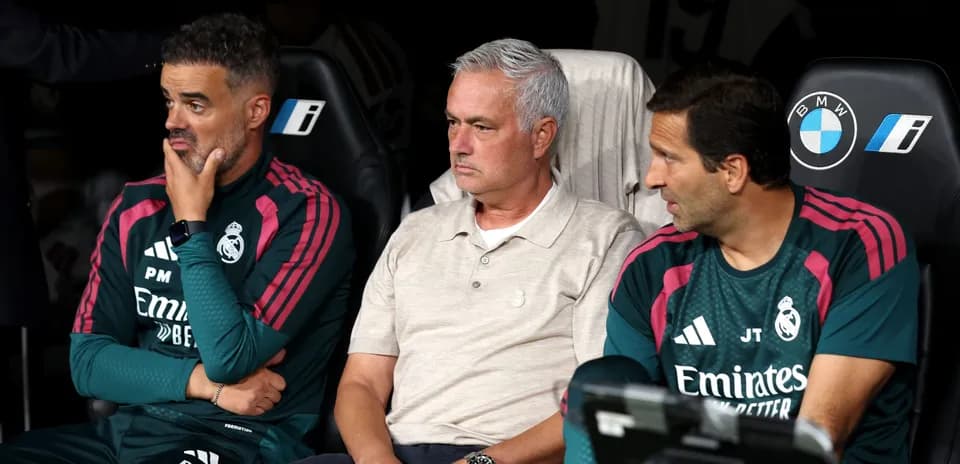 Coaching staff seated on bench during match
