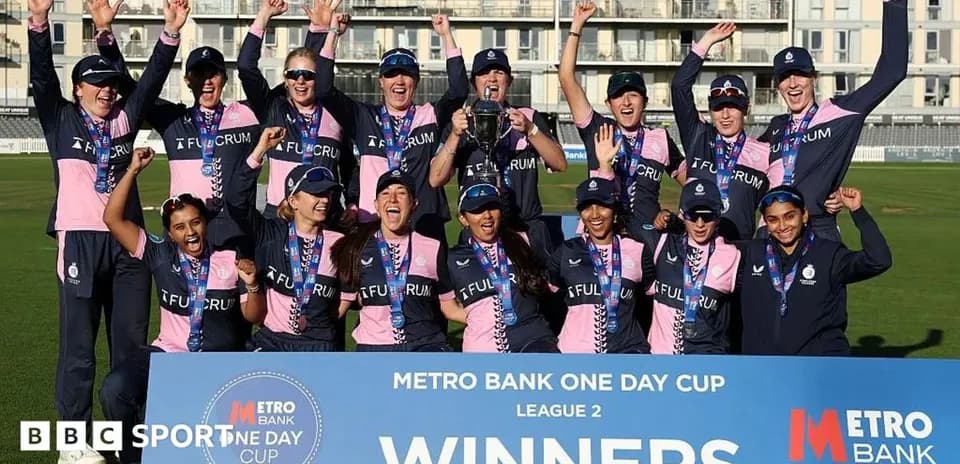 Cricket team celebrating victory with trophy and medals