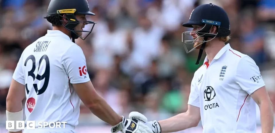 Two cricketers shaking hands on the field
