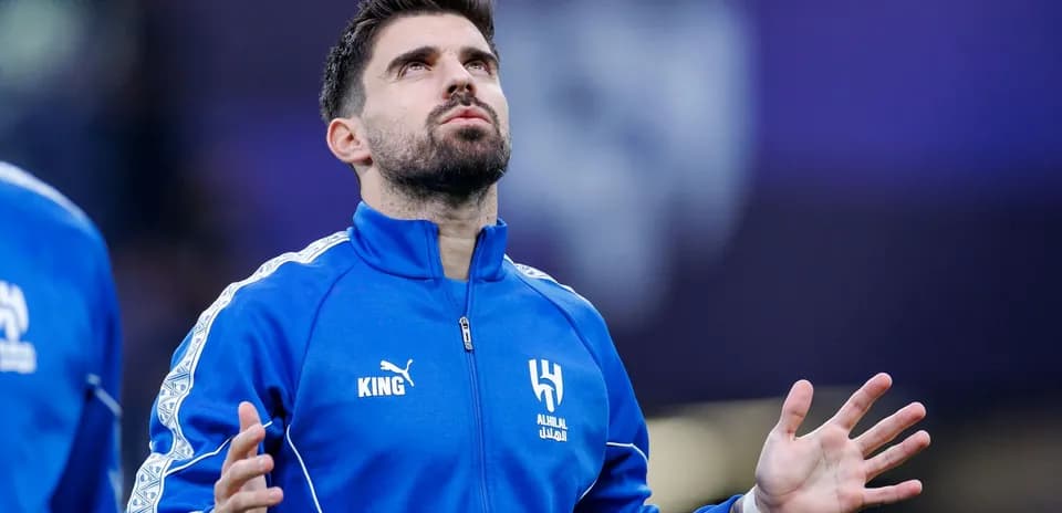Player in blue tracksuit looking up before match