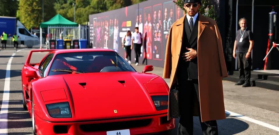Man in stylish coat beside red sports car