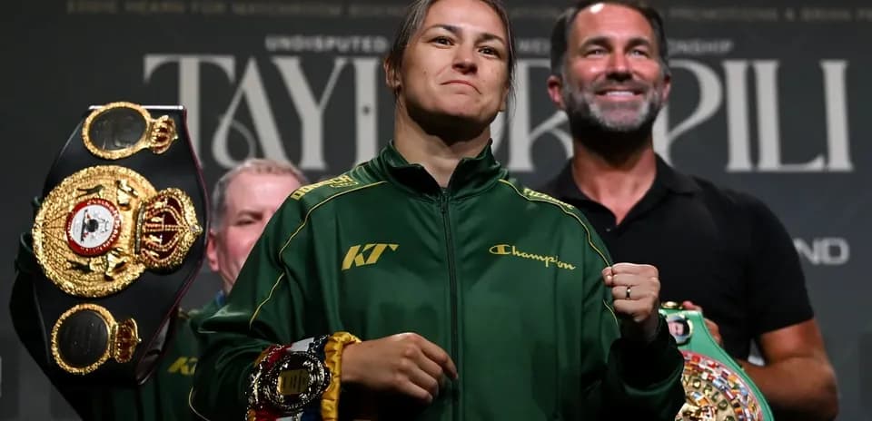 Boxer holding championship belts at press event
