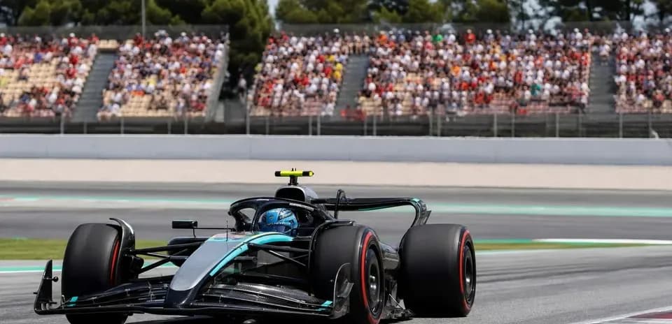 Formula 1 car racing on track with spectators in background