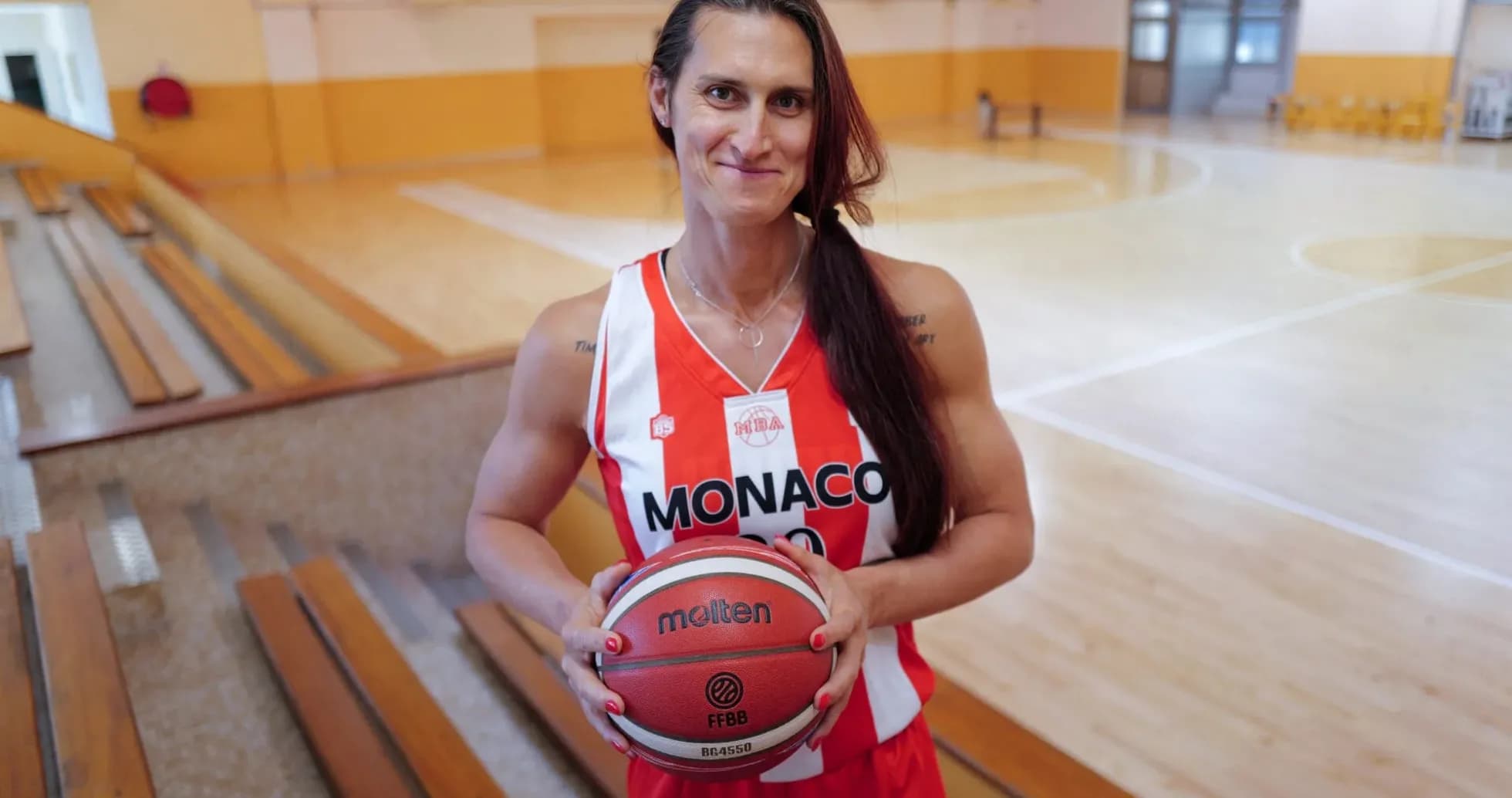 Player in Monaco jersey holding basketball in gym