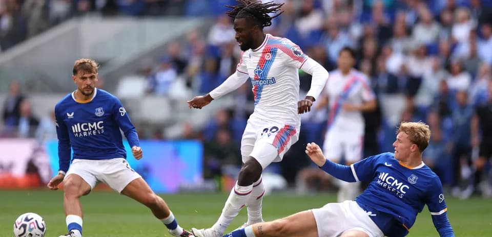 Player in white evading two defenders during match