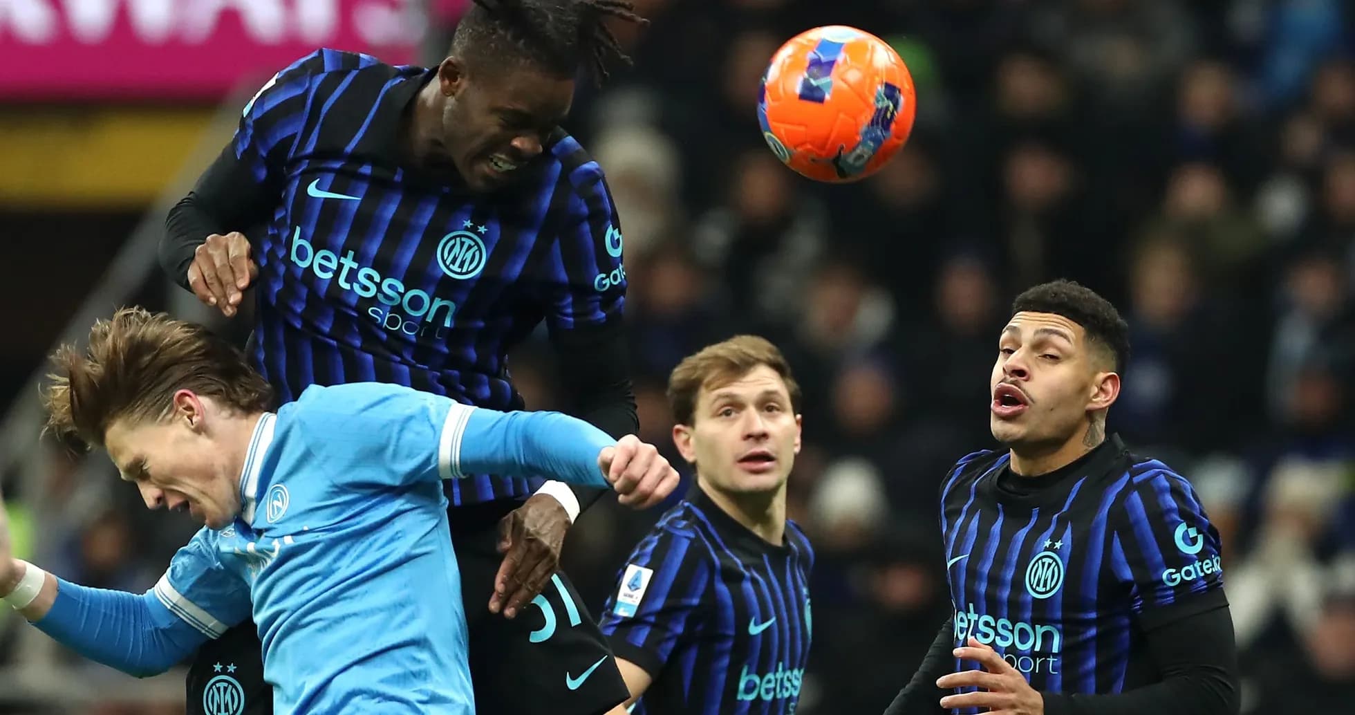 Players contesting a header during football match