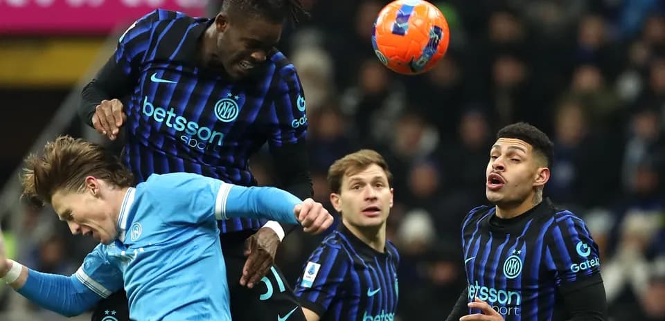 Players contesting a header during football match