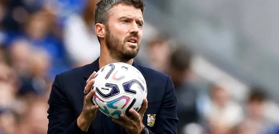 Coach holding a soccer ball on the sidelines