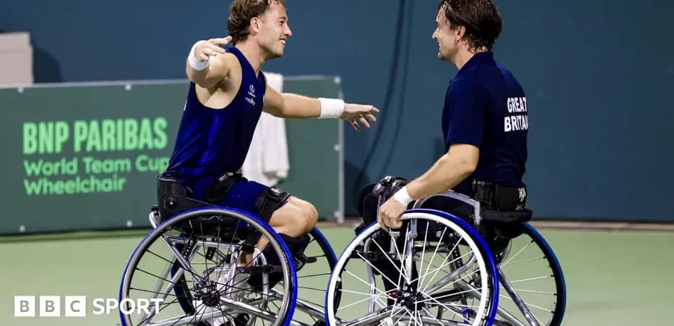 Two wheelchair tennis players celebrating on court