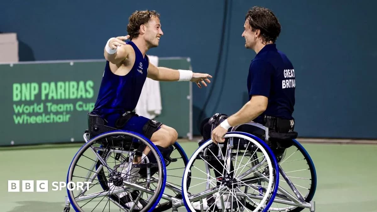 Two wheelchair tennis players celebrating on court