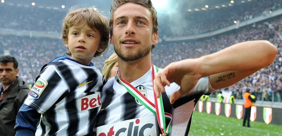 Player holding child on the field with medal