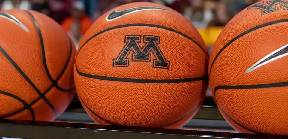 Basketballs with Minnesota logo on bench