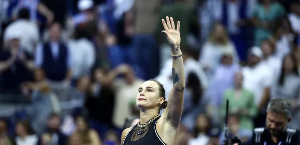 Tennis player waving to crowd after match