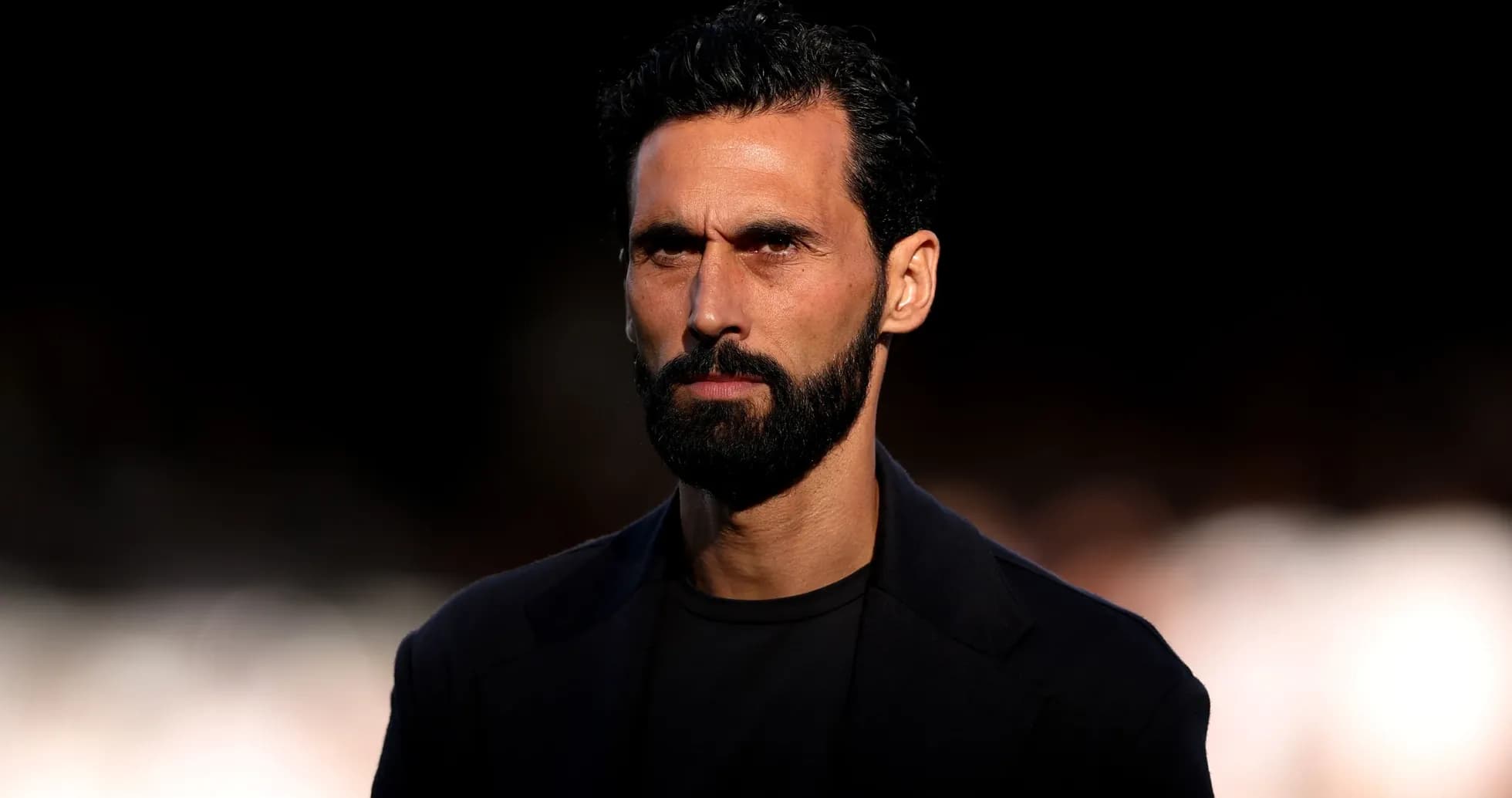 Man with beard and serious expression on stage