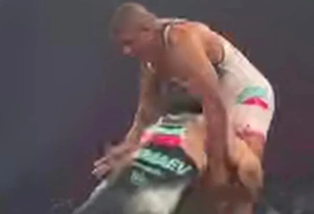 Two wrestlers engaged in a match on the mat