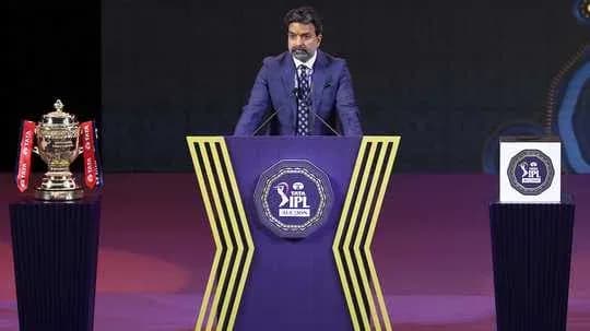Speaker at IPL event with trophy and podium