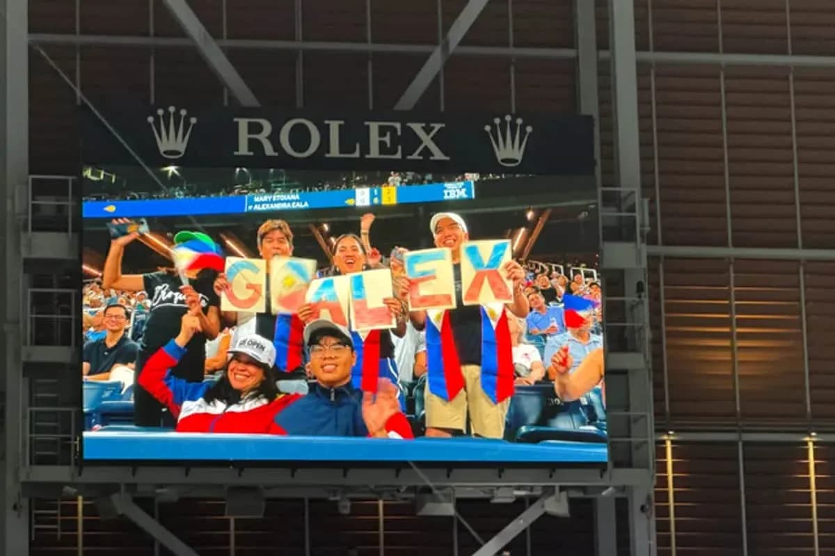 Fans holding signs supporting player Alex during match