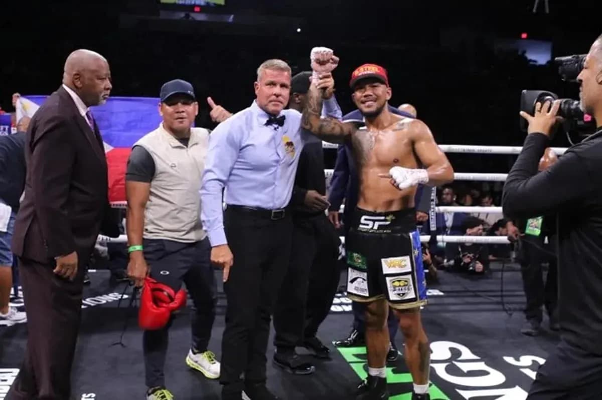 Boxer celebrating victory with referee and team members
