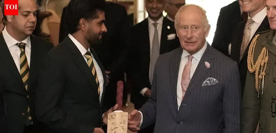 Cricket players presenting a signed bat to King Charles
