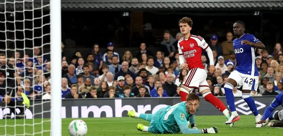 Arsenal player celebrating after scoring against goalkeeper