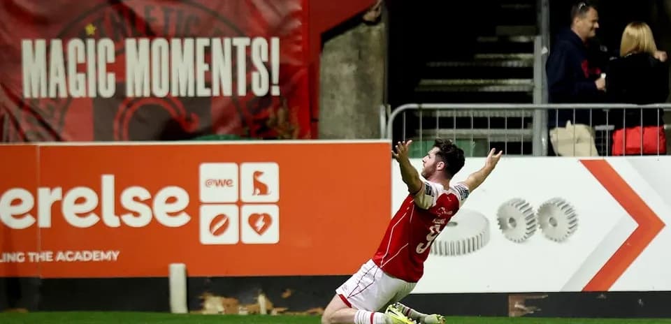 Player celebrating a goal in front of fans