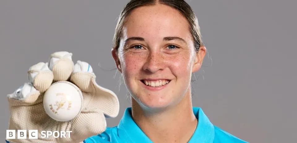 Cricketer holding a ball and smiling
